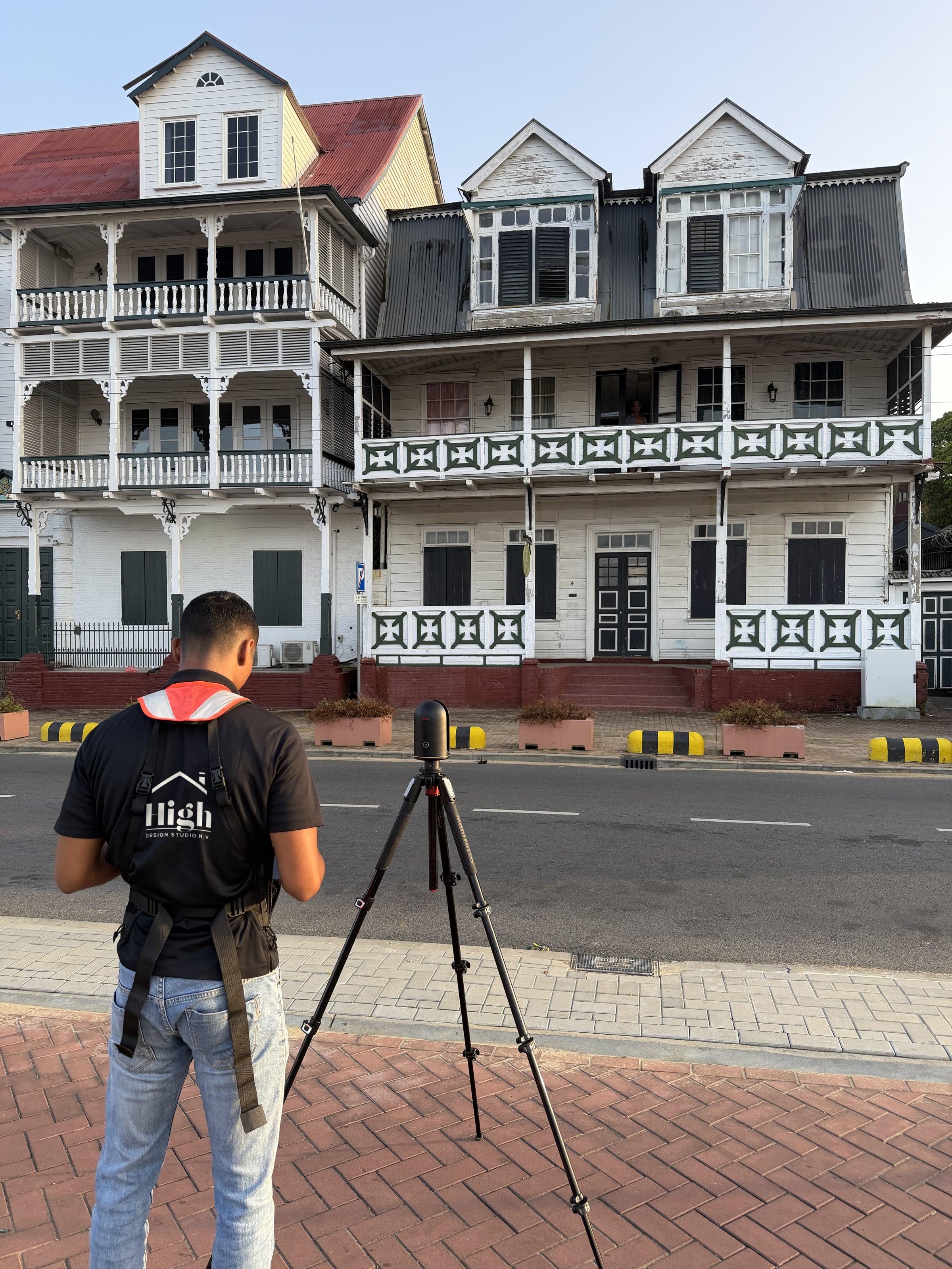 Collega van High Design Studio meet een historisch houten pand aan de Waterkant in met een laserscanner op statief